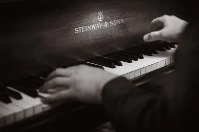 Schwarzweißaufnahme zweier Hände auf den Tasten eines Steinway-Flügels