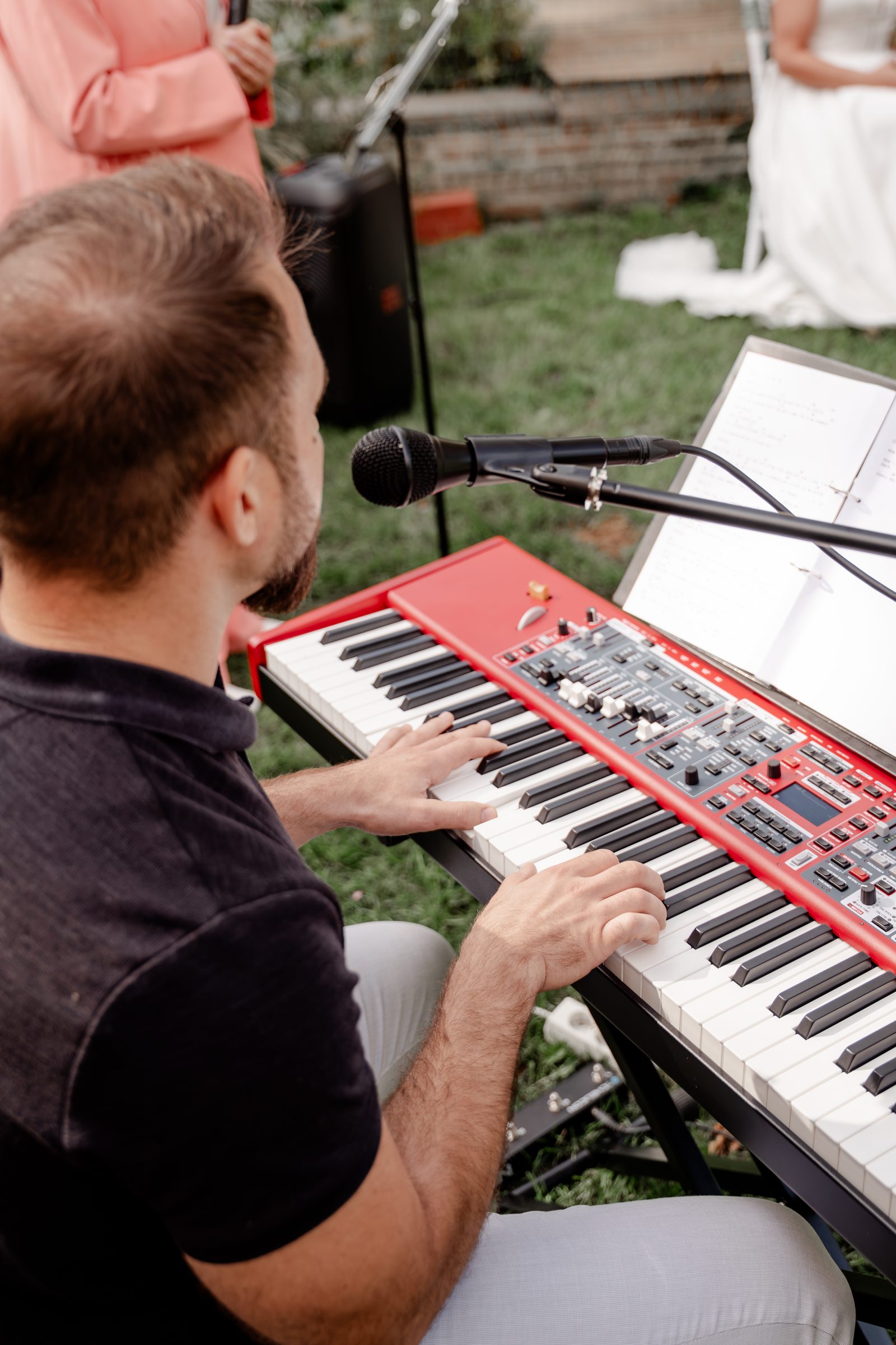 Ein Musiker spielt bei der Trauung Keyboard und singt, im Hintergrund die Braut
